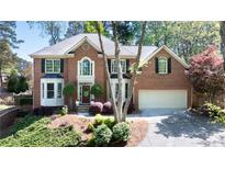 Charming two-story brick home featuring manicured landscaping and a well-maintained front yard and a two-car garage at 5405 Preserve Cir, Johns Creek, GA 30005
