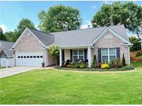 Charming single-story home features a brick facade, well-manicured lawn, and attached garage at 4025 Mcdowell Dr, Acworth, GA 30101