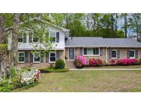 Charming brick home featuring a well-manicured front yard, blooming azaleas, and a mix of traditional and modern architectural elements at 4841 Village North Ct, Atlanta, GA 30338