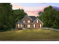 Charming two-story brick home with lush green lawn and mature trees at 1213 Blue Springs Dr, Loganville, GA 30052