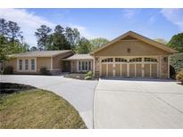 Charming single-story home featuring a welcoming entrance, beautiful landscaping, and a spacious three car garage at 3025 Greenfield Dr, Marietta, GA 30068