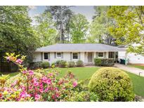 Charming brick home with a well-maintained front yard and colorful azalea bushes at 1295 Lindenwood Ne Ln, Brookhaven, GA 30319