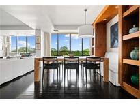 Bright dining room with dark wood floors, modern table set, built-in shelving, and lots of natural light at 145 15Th Ne St # 435, Atlanta, GA 30309