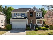 Charming two-story home boasts a well-manicured lawn and a two-car garage at 985 Forest Knoll Court, Lithia Springs, GA 30122