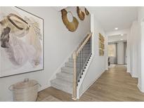 Bright foyer with staircase featuring gray carpet, black railings and light wood trim, leading to the upper level at 8511 Polston Place- Lot 138, Douglasville, GA 30134