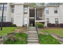 Multi-story condo with neutral colors, landscaping, and exterior stairs leading to upper level units at 2201 Huntingdon Chase St, Atlanta, GA 30350