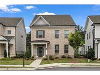 Charming two-story brick home with a covered front porch and professionally landscaped front yard at 1179 Bennett Creek Overlook, Suwanee, GA 30024