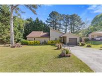 Charming home with well-manicured lawn, lush landscaping, and attached garage at 2520 Hartford Dr, Ellenwood, GA 30294