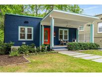 Charming blue bungalow with vibrant orange door and inviting covered front porch with rocking chairs at 830 Belgrade Ne Ave, Atlanta, GA 30306