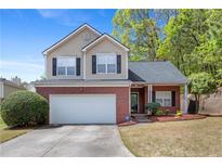 Charming two-story home featuring a brick facade, vinyl siding, and a well-maintained front yard with mature trees at 395 Anvil Way, Austell, GA 30168
