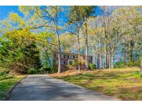 Charming two-story brick home with a long driveway surrounded by lush trees and greenery at 4510 Trumble Ter, Snellville, GA 30039