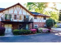 Charming townhome with brick facade, upstairs balconies, and colorful flowering bushes at 1181 Church St # D, Decatur, GA 30030