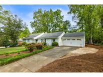 Charming one-story home with a well-maintained lawn, mature trees, and a two-car garage at 568 Timberland Dr, Atlanta, GA 30342