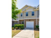 Charming townhome with brick and siding, featuring an attached one-car garage and well-maintained landscaping at 8475 Douglass Trl, Jonesboro, GA 30236