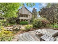 Expansive backyard featuring lush landscaping, stone patio, pond, and cozy lounge chairs for ultimate relaxation at 3749 Watkins Ne Pl, Brookhaven, GA 30319
