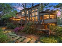 Stunning backyard featuring a multi-level deck, lush landscaping, and a charming stone path at 3749 Watkins Ne Pl, Brookhaven, GA 30319