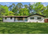 Charming white brick home with a lush green lawn and inviting front porch at 4442 Mark Anthony Ct, Decatur, GA 30035