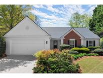 Charming single-story home featuring a brick accent, manicured landscaping and an attached two-car garage at 5755 Haterleigh Dr, Alpharetta, GA 30005