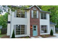 Charming two-story home with a brick accent, large windows, and a welcoming blue door at 5728 Norman Ct, Atlanta, GA 30349