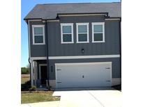 Modern two-story townhouse with a two car garage and manicured lawn at 860 Point Place Dr, Loganville, GA 30052