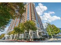 Modern high-rise exterior with balconies, situated in a lively urban setting with sidewalks and lush trees at 1820 Peachtree Nw St # 804, Atlanta, GA 30309