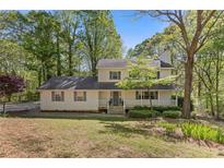 Charming two-story home with a welcoming front porch and lush green trees surrounding the property at 2315 Fisher Dr, Loganville, GA 30052