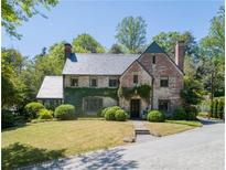 Charming brick two-story home with a well-manicured lawn and lush landscaping at 2648 Rivers Nw Rd, Atlanta, GA 30305