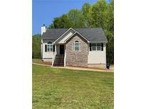 Charming single-Gathering home with stone accents, neutral siding, and manicured lawn at 305 Pleasant Forest Dr, Temple, GA 30179