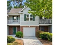 Charming townhome featuring a one-car garage, balcony, and a well-maintained lawn at 4643 Grand Central Pkwy, Decatur, GA 30035