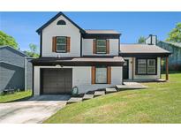 Charming two-story home with a manicured lawn, black trim, wood shutters, and attached garage in a suburban neighborhood at 1703 Laurel Creek Cir, Lithonia, GA 30058