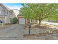 Charming two-story home featuring a well-maintained front yard with mature tree, a driveway, and attached garage at 200 Arrowhead Ln, Canton, GA 30114