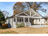 Charming home with a gray exterior, a covered porch and a spacious carport, all sitting on a well-maintained lot at 221 Silver Springs Sw Cir, Atlanta, GA 30310