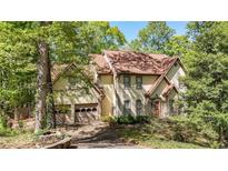 Two-story home featuring an attached two-car garage and landscaped yard with mature trees at 3200 Country Club Nw Ct, Kennesaw, GA 30144
