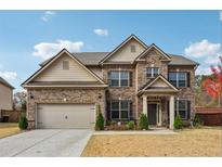 Charming two-story brick home with a well-manicured lawn and attached two-car garage at 1645 Dahlia Dr, Cumming, GA 30040