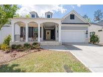 Charming home features a welcoming front porch, a two-car garage, and a well-manicured lawn at 460 Marston Pass, Acworth, GA 30102