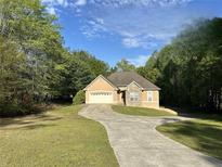 Charming single-story home with a stone accent, a two-car garage, and a welcoming curved driveway at 4383 Post Rd, Winston, GA 30187