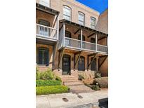 Charming brick townhouse featuring a covered porch and well-maintained landscaping at 9062 Selborne Ln, Palmetto, GA 30268