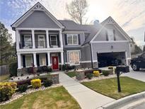 Charming two-story home featuring a covered porch, well-manicured lawn, and attached two-car garage at 2582 Corey Park Dr, Loganville, GA 30052