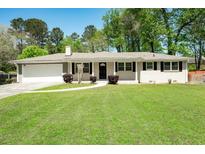 Charming brick home with a well-manicured lawn and inviting front porch at 4284 Carlos Ct, Powder Springs, GA 30127