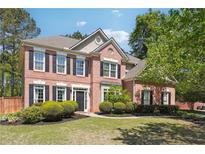 Charming two-story brick home with manicured lawn and lush landscaping creates inviting curb appeal at 715 Aronson Lake Ct, Roswell, GA 30075