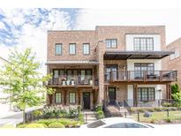Beautiful brick townhome featuring a covered balcony and professionally landscaped front yard at 1952 Maritime Way, Atlanta, GA 30318