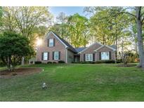Charming brick home with a well-manicured lawn and mature trees offers inviting curb appeal at 2380 Emerald Dr, Loganville, GA 30052