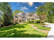 Charming stone and wood home with manicured lawn and lush landscaping at 5178 S Trimble Rd, Atlanta, GA 30342