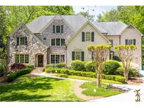 Inviting traditional home featuring a stone facade, manicured lawn, and lush landscaping at 5178 S Trimble Rd, Atlanta, GA 30342