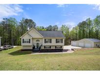 Charming two-story home with manicured lawn and detached garage at 127 Pebblebrook Way, Temple, GA 30179