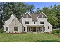 Beautiful two-story home featuring white siding, decorative gables, and a welcoming front porch with rocking chairs at 284 Hook St, Alpharetta, GA 30009