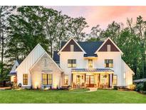 Inviting two-story home featuring a well-manicured lawn and a charming front porch with rocking chairs at 284 Hook St, Alpharetta, GA 30009