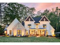 Charming exterior featuring a well-manicured lawn, white siding, brick accents and a cozy front porch with rocking chairs at 284 Hook St, Alpharetta, GA 30009