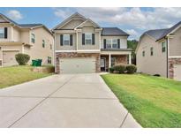 Charming two-story home features a stone facade, attached garage and well maintained lawn at 486 Crestmont Ln, Canton, GA 30114