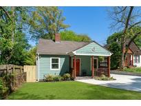 Charming renovated bungalow with a cozy front porch, freshly painted exterior, and lush green lawn at 1518 Langston Sw Ave, Atlanta, GA 30310